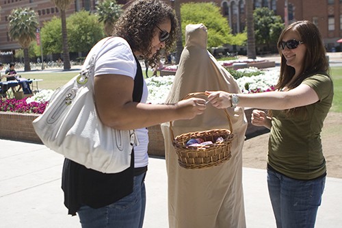 Ginny Polin/ Arizona Daily Wildcat

Astrid Eskridge (left), a family studies and human development freshman, grabs a few condoms from Brittany Robertson and Mr. Condom Wednesday during Sexually Transmitted Diseases Awareness Day.  April is STD Awareness Month, and campus health is encouraging everyone to get tested.

