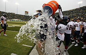 UA head coach Mike Stoops gets water dumped on him by cornerbak Wilrey Fontenot (3) during the waning seconds of the fourth quarter of Arizonas game 37-10 upset win at Oregon Saturday at Autzen Stadium. The Wildcats became bowl-eligible for the first time since 1998 with the win.