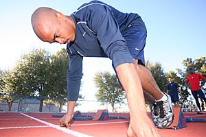 Senior sprinter Troy Harris sets up in the starting blocks during yesterdays practice at Drachman Stadium. Harris has thrived as a sprinter while also walking on to the football team, maintaining a 4.0 grade point average, serving as a resident assistant and working for UATV.