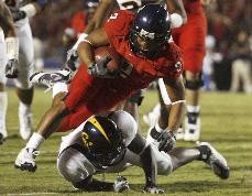 UA running back Keola Antolin plows over a California defender during the Wildcats 42-27 win over the No. 25 ranked Golden Bears at Arizona Stadium Saturday night. Antolin gained 149 yards on 21 carries and scored three touchdowns in the game.