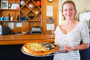 Jessica Ellis, daughter of Zacharys Pizza owner Dave Ellis, displays one of the famous pies that Zacharys is known for. 