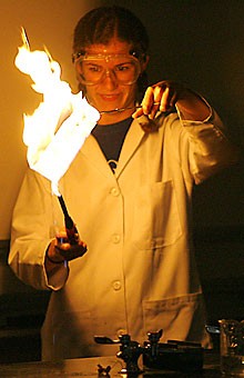 Physiology sophomore Danielle Correia burns paper during a chemistry magic show for an audience in the Old Chemistry building on Saturday.