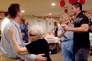 Pre-business freshman Bobby McCarthy, left, dances with 96-year-old Ruth Protas and pre-business freshman David Oberlander, right, dances with Beatriz Liebesman at the senior prom. The event was held at Atria Campana del Rio yesterday afternoon and organized by Pi Beta Phi and Delta Chi.
