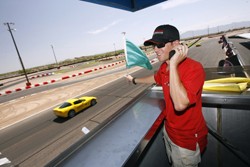 A Bondurant School of High Performance Driving instructor waves the green flag during start practice while Elizondo drives by last Wednesday.