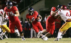 UA guard Joe Longacre (75) leads the way for running back Nic Grigsby during a 17-10 Wildcat loss to USC Oct. 25 at Arizona Stadium. Longacre and the rest of the UA offensive line are a big reason the Wildcats lead the Pacific 10 Conference in points per game (39.11) and rank 33rd in the nation in average total offense (400.22 yards). 
