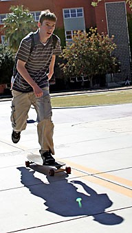 Computer science sophomore Tim Arnold rides his long-board on campus to get from class to class.  The UA has passed rules against skateboarders and long-boarders doing tricks, or as they call hot dogging, on campus and has limited board use solely to transportation purposes.