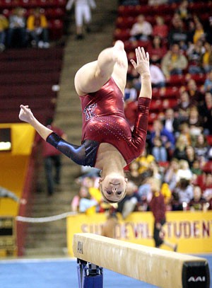 UA freshman Colleen Fisher flips on the balance beam at the gymnastics meet in Wells Fargo Arena in Tempe on Friday. Bergeson tied for second with a 9.850 on the beam, helping the No. 20 Gymcats to upset No. 17 ASU 195.925 - 195.725.