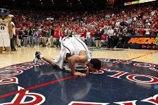 Arizona senior David Bagga kisses the court in McKale Center on Saturday after he was honored for his time as a Wildcat. The walk-on guard is a fan favorite despite what his career stat sheet reflects.