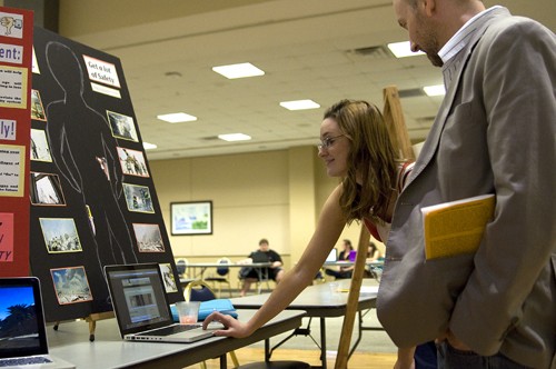 Tim Glass / Arizona Daily Wildcat

Kelley Clark, an engineering freshman, explains her essay and website to Ron Lorette, an English instructor, at the Grand Ballroom in the Student Union Memorial Center on Tuesday, April 20, 2010.  Clarks display was one of many being showcased at the Writing Showcase.