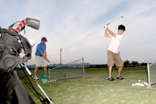 Lisa Beth Earle /Arizona Daily Wildcat 

UA golf club members Samuel Angart, left, a material sciences and engineering freshman and Alex Chiya, an aerospace engineering freshman, practice their swings at The Practice Tee on Tuesday, April 27. 