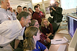 Alfred McCwen (white button down shirt) and his team look at the first images taken of Mars by their HiRISE camera on Friday , March 24, 2006 in the Sonnet Building in Tucson, Arizona. The HiRISE camera onboard an orbiting Mars probe sent back its first images of the surface at around 1:30 a.m. with resolutions over 2.5 meters per pixel.
(Photo by Jake Lacey/Arizona Daily Wildcat)