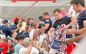 Kyle Day (82), Cole Graybill (48) and John Sanders (15) sign autographs for fans at the football teams Meet the Team event Saturday at Arizona Stadium. Around 8,500 fans came out to watch the teams final scrimmage.
