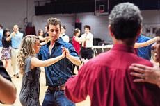 Zach Madick, a pre-business sophomore, and Dayna Madick learn how to tango dance at Tango El Gato in Bear Down Gym on Saturday night.