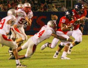 UA wide receiver Mike Thomas (10) tries to wriggle free from the grasp of New Mexicos Jerome Jenkins (24) in last years 29-27 Lobo win at Arizona Stadium. The Wildcats look to return the favor in Saturdays game in Albuquerque at 5 p.m.