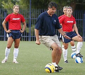 Soccer coach Dan Tobias shows off his dribbling skills as sophomore forward Gianna DeSaverio, right, and junior defender Claire Bodiya look on. Tobias will need some of that magic to help overcome the loss of star goalkeeper McCall Smith, who is out for the season with an injury.
