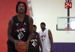 Arizona guard Nic Wise, backgroud left, and former Wildcat Hassan Adams talk while UA forward Jordan Hill preps for a free throw in a Tucson Summer Pro League game at the Northwest Center. Adams, who has a full year of NBA experience, is one of many former Arizona players to return to Tucson after theyve gone pro.