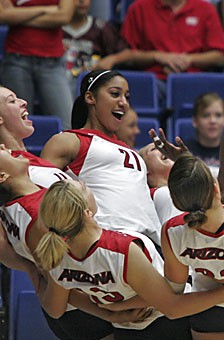 Freshman Whitney Dosty (21) and her teammates take part in a pre-game ritual prior to the volleyball teams 3-1 loss to ASU Friday in McKale Center. The No. 4 recruit in the country and the No. 1 recruiting target of UA head coach Dave Rubio, the Tucson native has lived up to expectations, being second on the team in kills.
