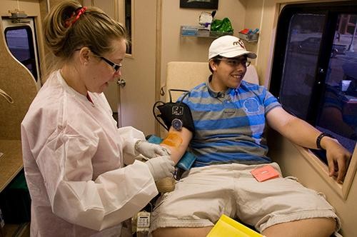 Robin Bush, a nurse with Red Cross since last October, prepares Senobio Pinela, a mechanical engineering student, for blood donation at a Red Cross mobile donation RV on Monday. 
