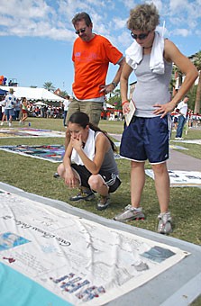 Tucson residents view pieces of an AIDS quilt yesterday on the UA Mall. The quilt was on display as part of the 2006 AIDSWalk.