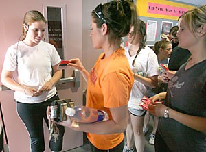 Physiology senior and fitness instructor Morgan Arnold checks students CatCards and fitness passes at the door of a core class yesterday at the Student Recreation Center. The Rec Center has sold so many passes that some students cannot attend every class.