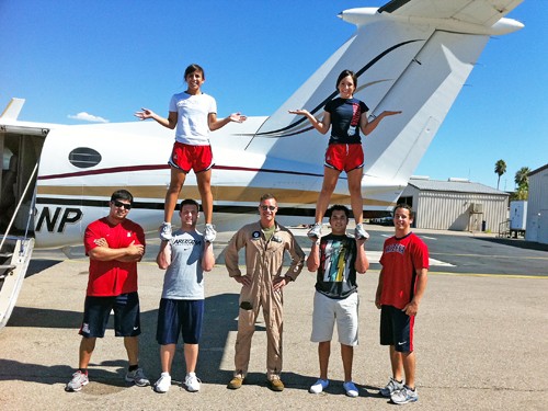 UA cheerleaders pose triumphantly with Capt. Rick Birt (center) at the Tucson Jet Center after taking turns flying the King Air 200 on Thursday, Sept 30.