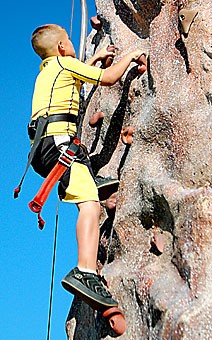 Tucson fourth-grader Shane Kelly climbs the rock wall at the Spring Fling carnival last Saturday afternoon.