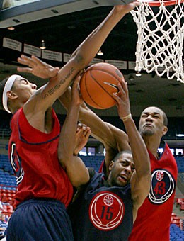 Senior point guard Mustafa Shakur (center) is stuck in a crowd between sophomore Marcus Williams (left) and freshman Jordan Hill on his way to a lay-up attempt. Shakur, who has started the last three seasons at point guard will try to create more space for himself when he plays in the Red Blue game today in McKale Center.
