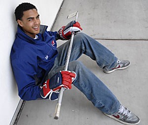 Icecats center Brandon Robinson, who is currently the only black athlete on the club hockey team, sits with his stick in hand. Robinson, a sophomore, is the fourth black member of the team in Icecats history, according to head coach Leo Golembiewski.