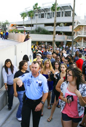 A security guard leads a seemingly endless line of Kanye West fans inside of the McKale Center last April for the highly anticipated concert that was made possible by ASUA. Students have high hopes for this years follow-up act that may potentially sell out 30,000 seats at Arizona Stadium.