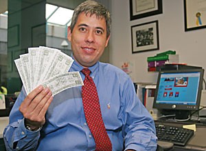 UA law professor Jack Chin sits in his office holding the fake money that was thrown around the room by Daily Show reporter Dan Bakkedal in an interview to air this week.  Chin was interviewed about Proposition 200, on Arizona ballots this November, that if passed would enter voters in a lottery for $1 million.