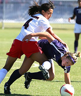 Arizona freshman Karina Camacho topples over a Washington player during the Wildcats 2-0 loss to the Huskies yesterday at Murphey Stadium. The team is now 0-2 in the 