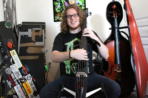 Lisa Beth Earle/ Arizona Daily Wildcat 

Tom Burrish, a psychology major and music minor, sits in his room with his electric cello. Burrish describes his music as a dichotomy between fixed and improvisational because he uses both his computer and various musical instruments to compose his music.