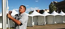Rigo Sanchez sets up one of the many tents that cover the UA Mall yesterday afternoon in preparation for the Tucson Festival of Books, which will take place March 14 and 15. 