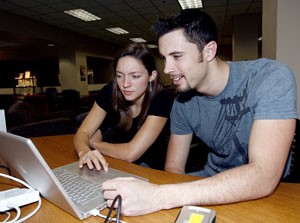 Second year medical students Hannah McLeod, left, and Stephen Pike look through footage of their video before editing it yesterday in the UMC library. McLeod and Pike are working on a video about a child with cancer and an amputated leg.