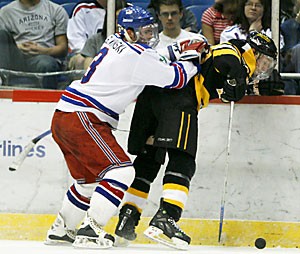 Forward Robbie Nowinski body checks a Long Beach State player during the Arizona mens club hockey teams 5-0 win Saturday night at Tucson Convention Center. The Icecats totaled 12 goals over a two-game set against the 49ers.
