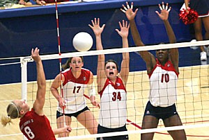 St. Marys outside hitter Megan York hits the ball as Arizonas Randy Goodenough (17) Paige Weber (34), and Dominique Lamb (10) attempt to defend in the final game of the Sheraton Four Points Wildcat Classic Saturday night in McKale Center. York, the tournaments MVP, led the Gaels past the Wildcats in five games.