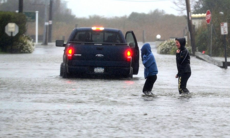 People make their way through a flooded street in Sayville, on Long Island's South Shore, Monday afternoon, October 29, 2012, as Hurricane Sandy gains strength. (Thomas A. Ferrara/Newsday/MCT)