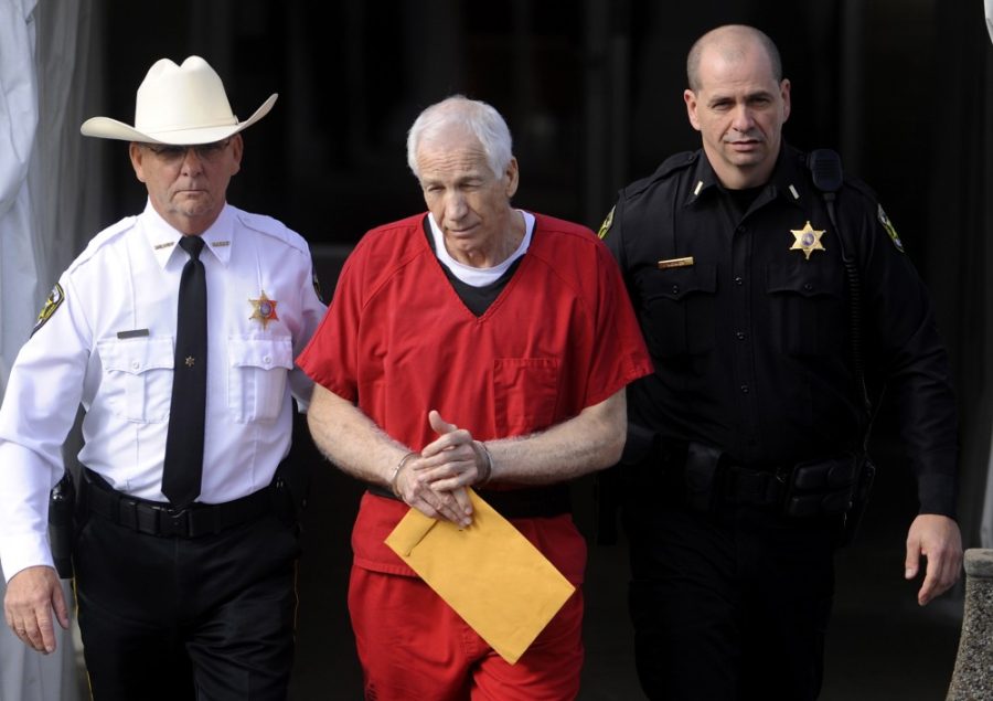 Jerry Sandusky, center, is escorted from his sentencing at the Centre County Courthouse in Bellefonte on Tuesday, October 9, 2012. Sandusky, maintaining his innocence, was sentenced Tuesday to at least 30 years in prison, effectively a life sentence, in the child sexual abuse scandal that brought shame to Penn State and led to coach Joe Paterno's downfall. (Christopher Weddle/Centre Daily Times/MCT)