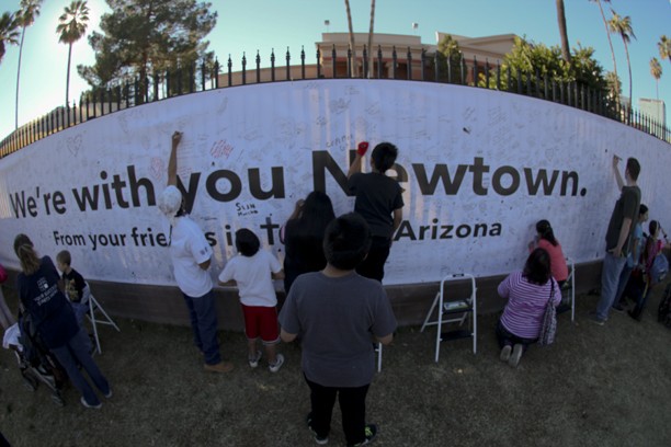 	Photo by Kyle Wasson/ Arizona Daily Wildcat

	Attendants at “Together We Move” signed a banner dedicated to Newtown, Conn. Pima Federal Credit Union, who printed the banner, will ship it overnight on Monday.   