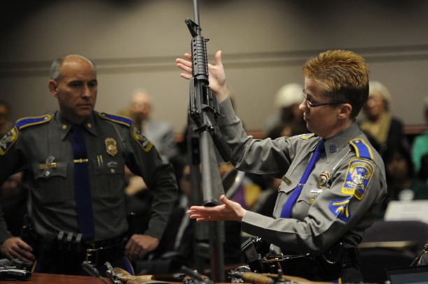 Detective Barbara Mattson of the Connecticut State Police Department displays a Bushmaster semi-automatic weapon during a hearing at the Legislative Office building in Hartford, Connecticut, Monday, January 28, 2013. (Cloe Poisson/Hartford Courant/MCT)