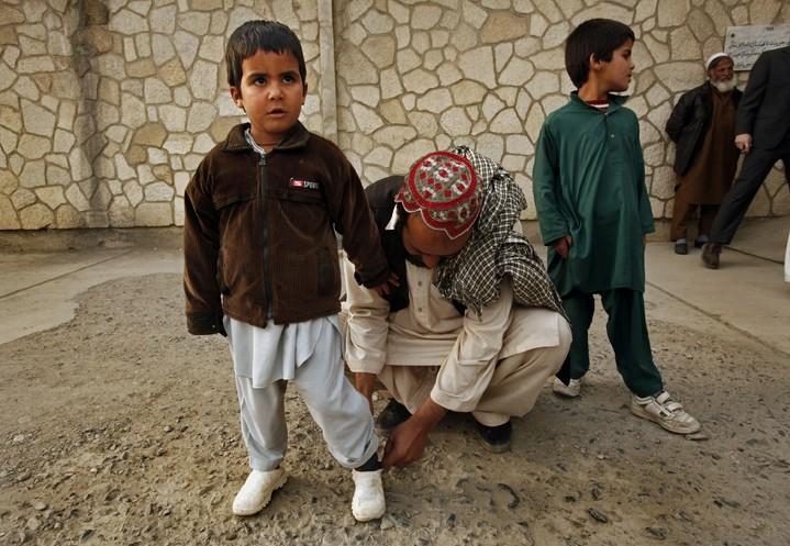 Five-year-old+Muqadas%2C+left%2C+gets+help+with+his+shoe+by+his+father+Mohammed+Anwar+outside+CURE+hospital+in+Kabul%2C+Afghanistan%2C+December+13%2C+2012.+Muqadas+was+shot+in+the+head+during+an+exchange+of+gunfire+between+Taliban+and+US+forces+in+Afghanistan.+His+father%2C+Mohammed+Anwar+took+him+directly+to+a+U.S.+base%2C+where+they+saved+his+life.+%28Carolyn+Cole%2FLos+Angeles+Times%2FMCT%29