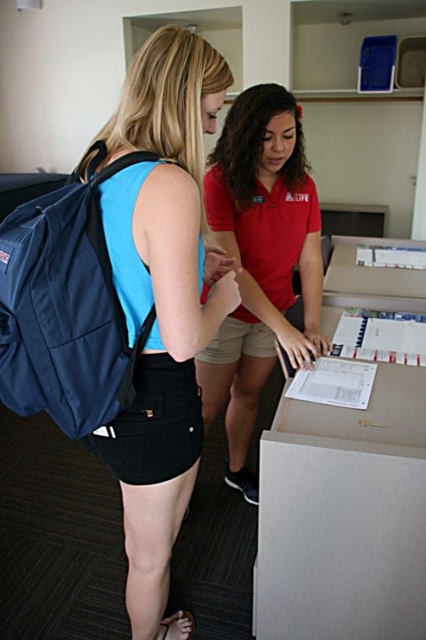 Michaela Kane / Arizona Daily Wildcat

Kaylie Foster (right), an resident assistant at Colonia de la Paz, helps freshman Hannah Roth (left) check into her room on Thursday, Aug. 22, 2013 in Tucson, Arizona. Foster is an RA in the same dorm where she lived as a freshman. 