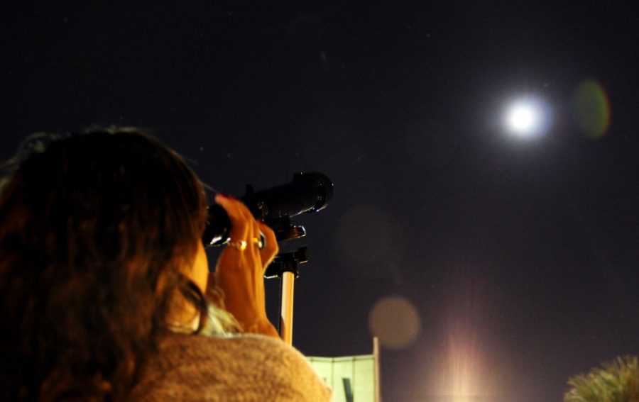 Mark Armao / The Daily Wildcat

Nikki White, a business sophomore peers at the moon through a telescope during International Observe the Moon Night. The moon was in its waxing gibbous phase during the event, which was held on the UA Mall Saturday.