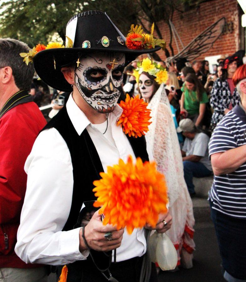 Michaela Kane /  The Daily Wildcat

Paul Pratt dresses up for the Dia de los Muertos parade in downtown Tucson on Sunday, Nov. 3. Pratt, like many others in the parade, was marching with photographs of deceased loved ones. 