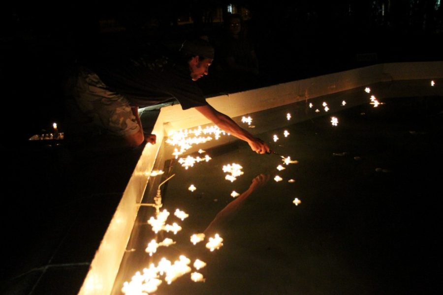 Ernie Somoza / Arizona Daily Wildcat

Chris Kosters, chemistry and cellular biology senior lights candles that were placed in the fountain in front of old main in remembrance of the 222 reported transgender deaths since last November 21. It is reported that a transgender person dies every other day.