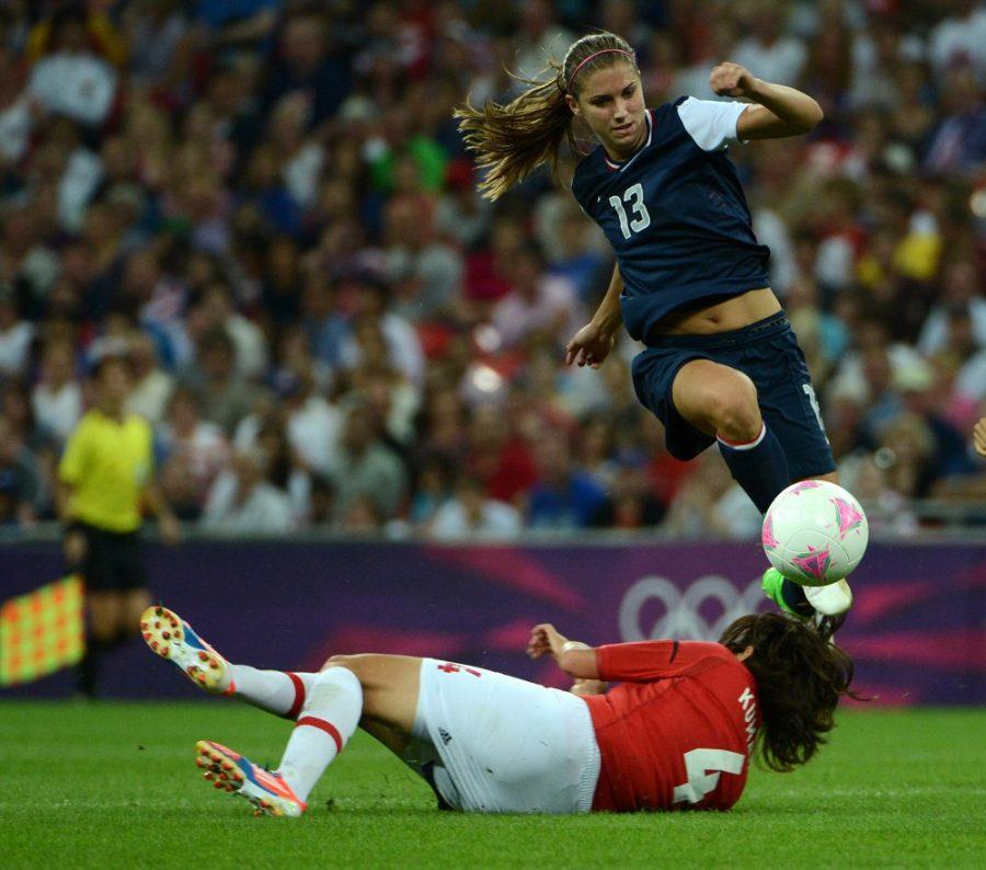 USA's Alex Morgan (13) jumps over Japan's Saki Kumagai (4) in the second half of the women's soccer final at Wembley Stadium in London, England, in the Summer Olympic Games on Thursday, August 9, 2012. The U.S. defeated Japan, 2-1, for the gold medal. (Nhat V. Meyer/San Jose Mercury News/MCT)