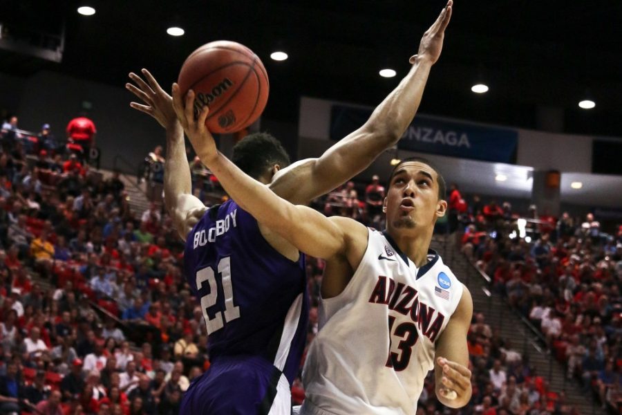 	Weber State sophomore forward Joel Bolomboy (21) tries to block Arizona junior guard Nick Johnson’s (13) shot during Arizona’s 68-59 win against Weber State in the second round of the NCAA Tournament at Viejas Arena in San Diego on Friday. 