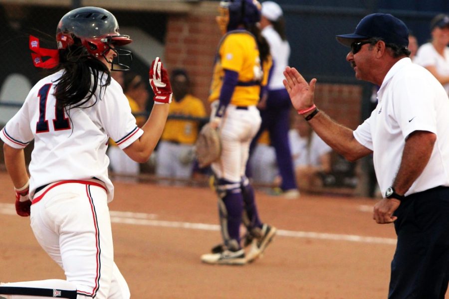 	Arizona freshman infielder Mo Mercado (11) high-fives Head Coach Mike Candrea after hitting a two-run home run in the last inning of Arizona’s 13-5 win against LSU in game seven of the NCAA Tucson Regional at Hillenbrand Stadium. Arizona had three home runs and advanced to the NCAA Super Regionals in Lafayette, La. 
