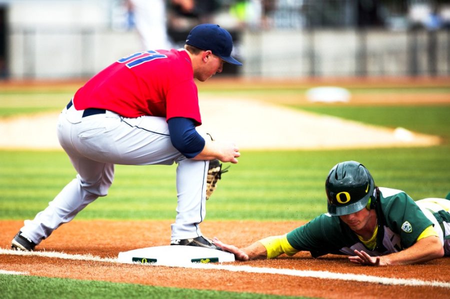 Oregon outfielder Tyler Baumgartner (13) slides back into first base. The Oregon Ducks play the Arizona Wildcats at PK Park in Eugene, Ore. on May 3, 2014. (Taylor Wilder/Emerald)