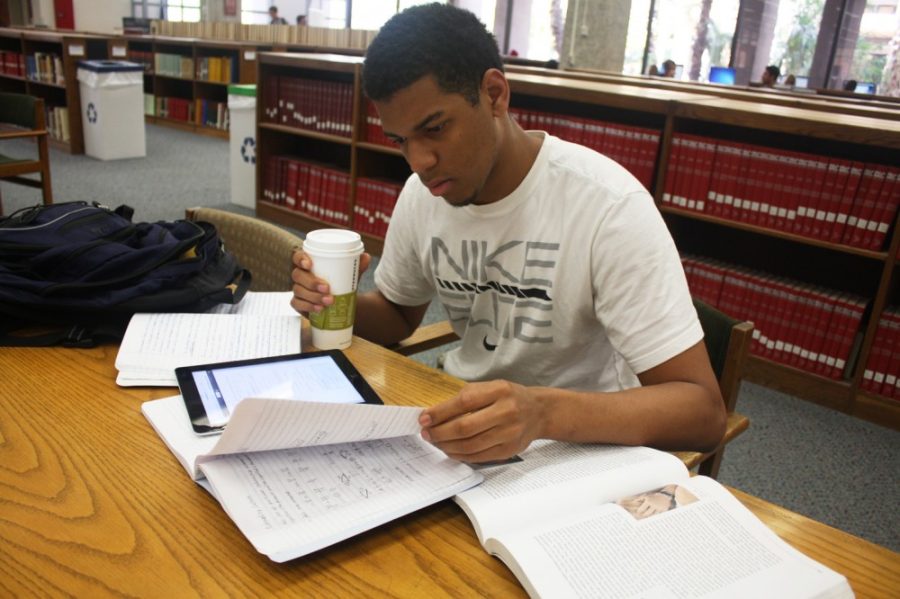 Freshman Wildcats Michael Lasswell and Joe Kimbuende preparing for Finals Week by studying class notes and reading textbooks. Both freshman were studying in the University of Arizonas Main Library on Thursday afternoon.

Michael Lasswell is in the NIKE Shirt
